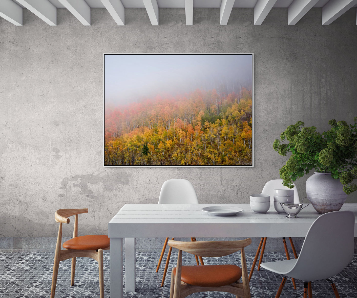 Aerial image of trees with fall colored leaves, and a heavy fog framed over a dining table.