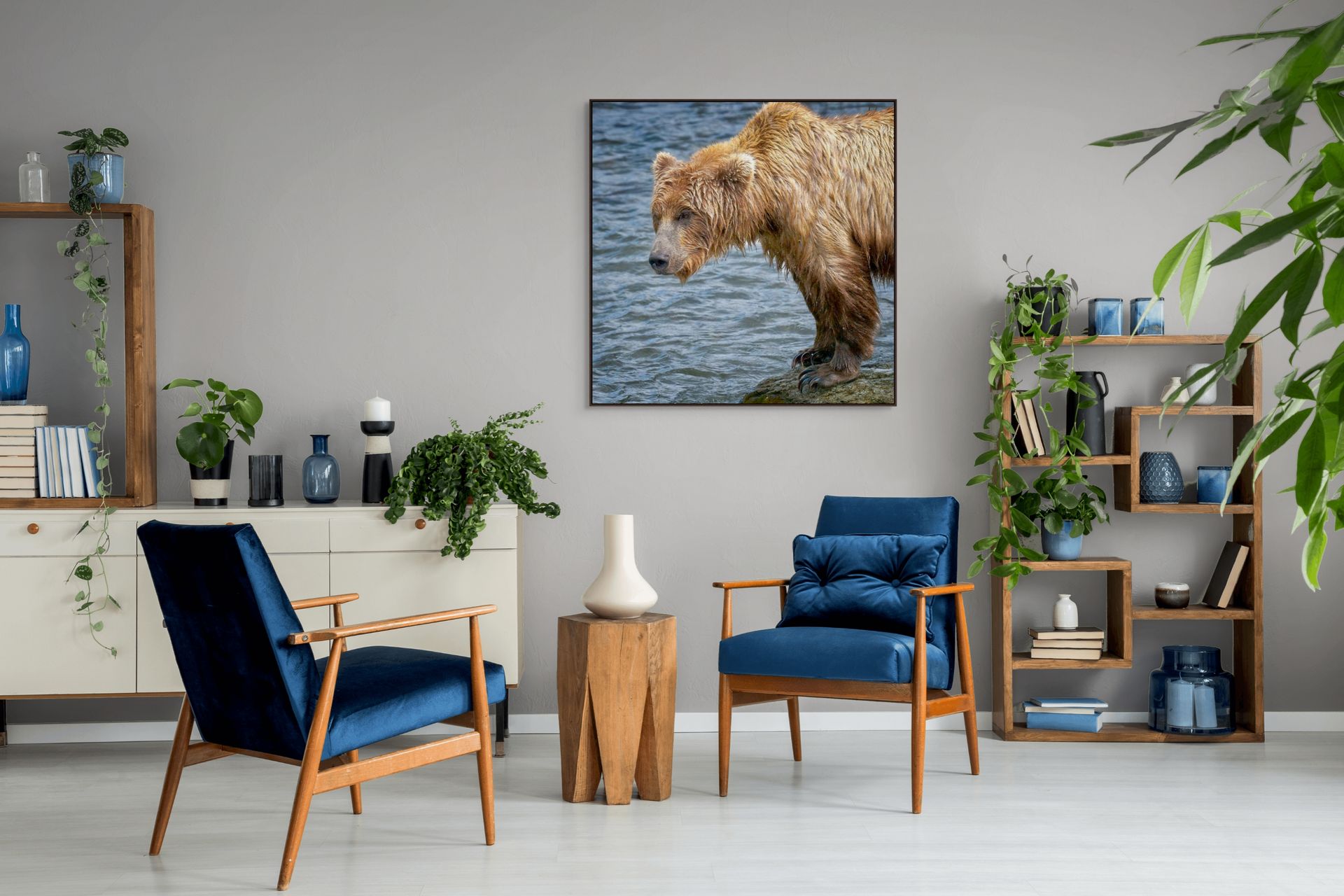 Image of a bear standing on a rock beside the water hanging above 2 chairs.