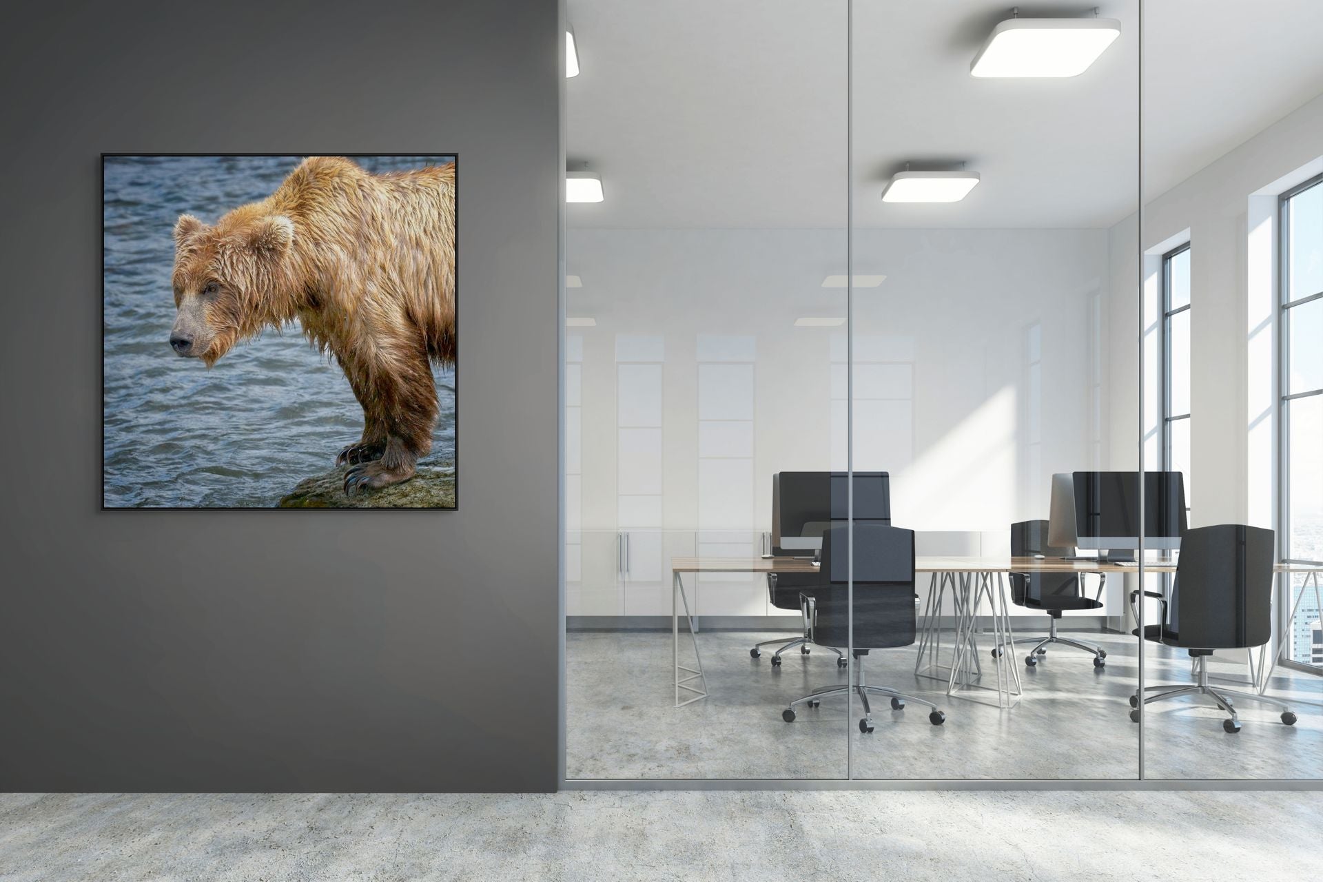 Image of a bear standing on a rock beside the water hanging in an office building.