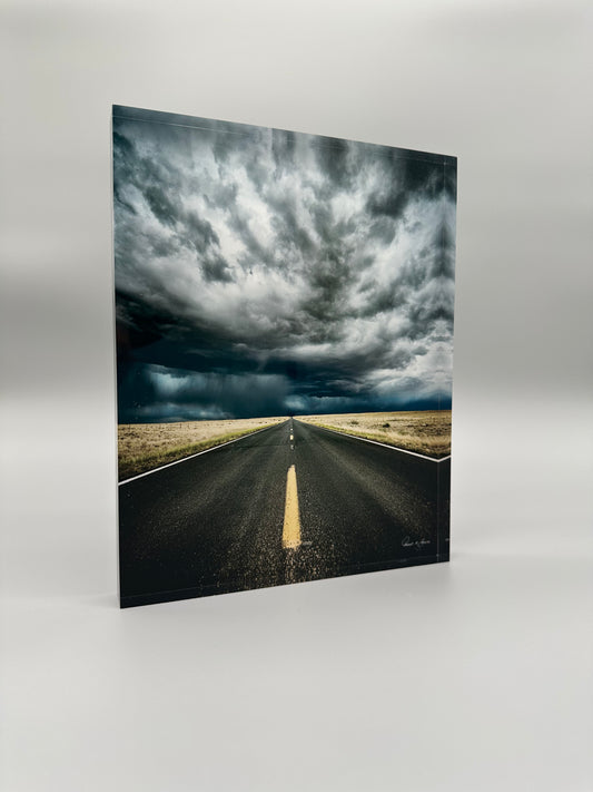 Road stretching into the distance with a dramatic sky above