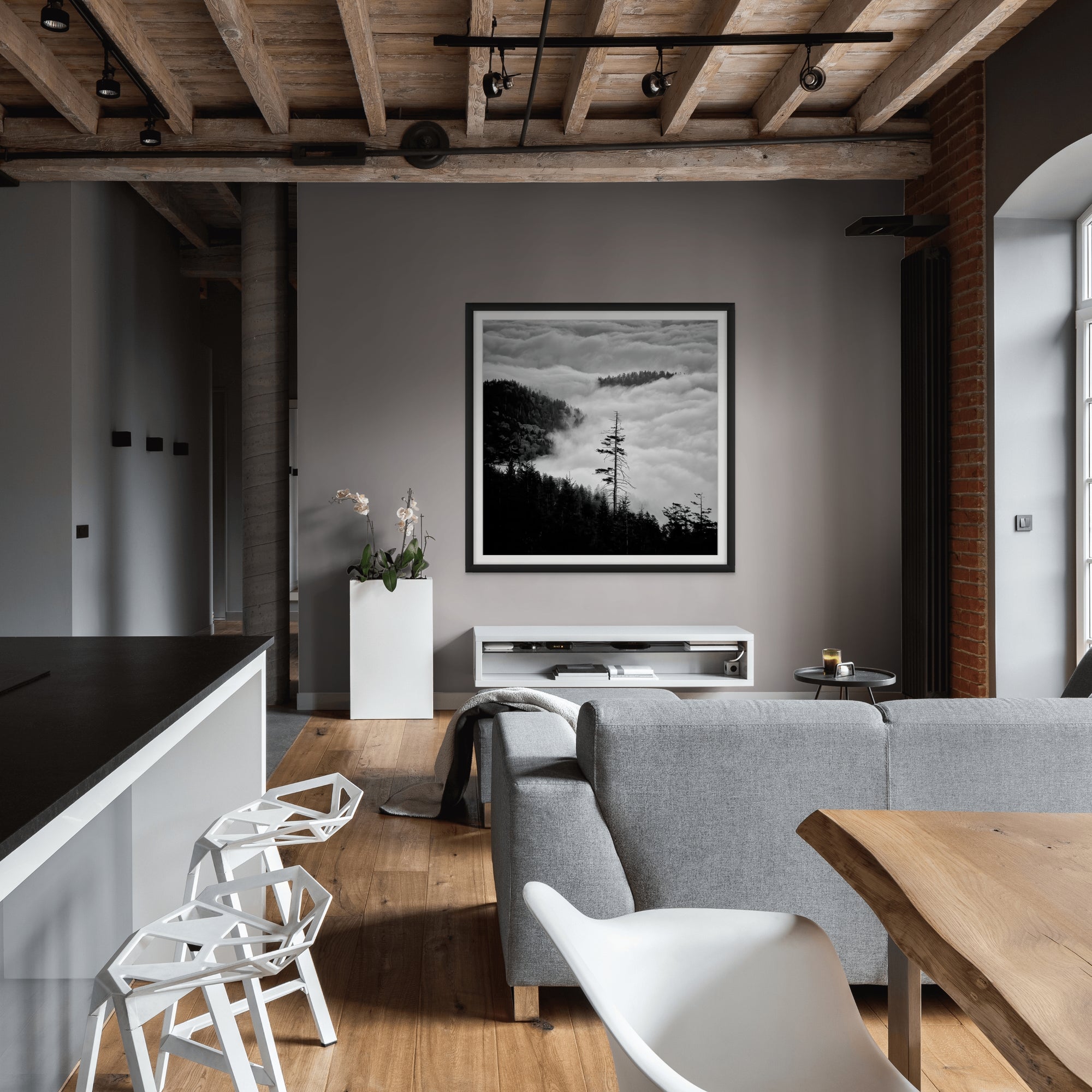 Image shot looking down mountain, clouds and trees in view, framed in a living room