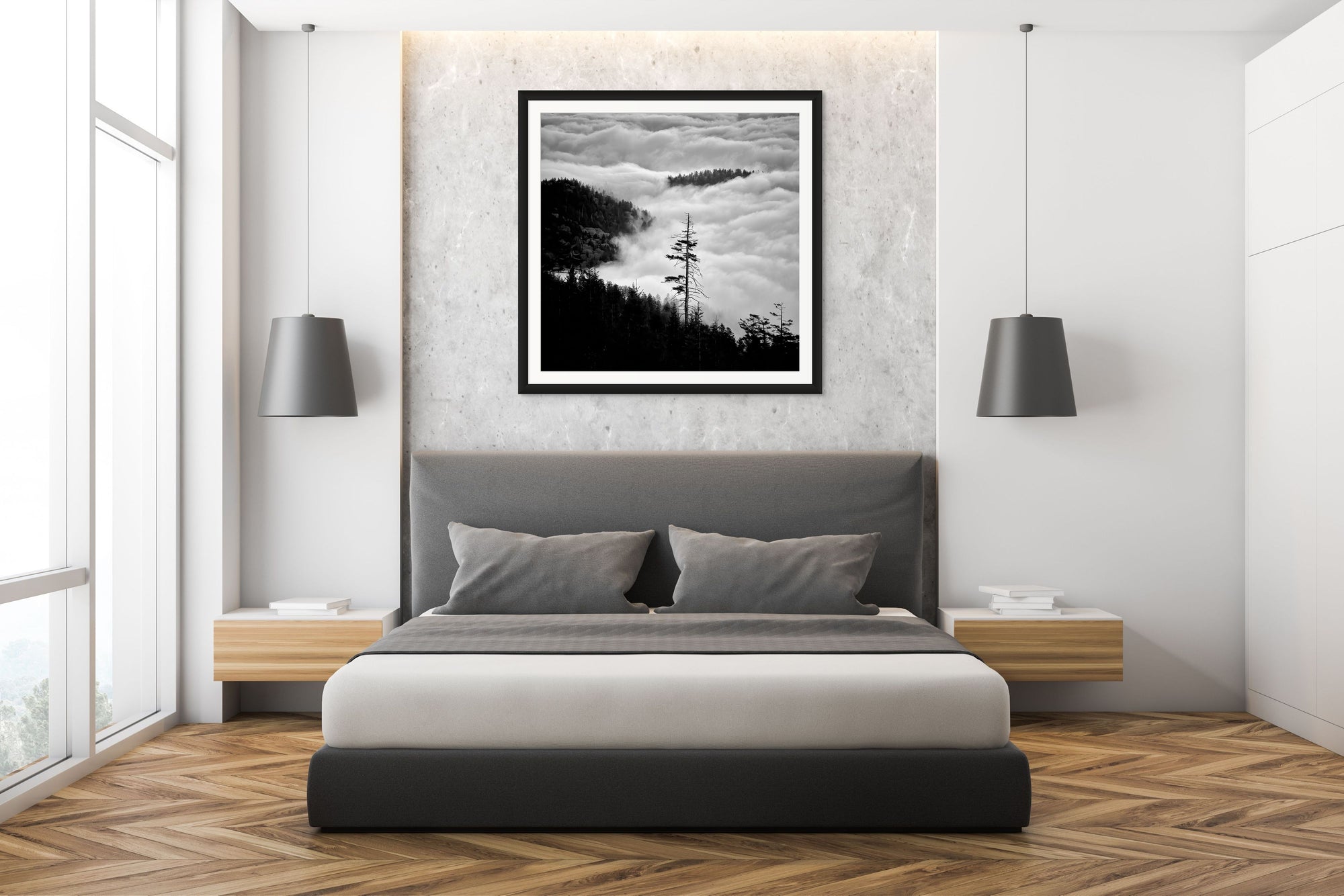 Image shot looking down mountain, clouds and trees in view, framed over a bed.