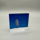 Acrylic block with a tree design on a blue and white background
