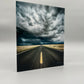 Road stretching into the distance with a dramatic sky above