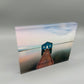 Acrylic print with a blue house and wooden pier on a gray background