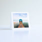 a postcard of a lake house with gradient sky